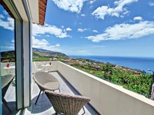 uma varanda com 2 cadeiras e vista para o oceano em Villa Liana by LovelyStay em Ponta do Sol