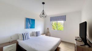 Schlafzimmer mit einem Bett und einem Flachbild-TV in der Unterkunft Villa Liana by LovelyStay in Ponta do Sol