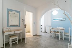 a white room with a table and a mirror at Livadia Seaside Studios 1 in Parikia