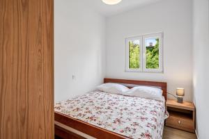 Schlafzimmer mit einem Bett und einem Fenster in der Unterkunft Apartments Zlarin in Zlarin