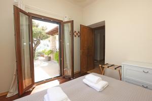 a bedroom with a bed and a large sliding glass door at Pine Cottage, Syros Island in Firókambos