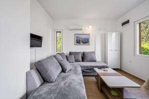 ein Wohnzimmer mit einem Sofa und einem Tisch in der Unterkunft Apartments Zlarin in Zlarin