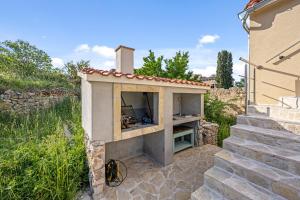 a small outdoor oven in a stone building at Apartments Zlarin in Zlarin