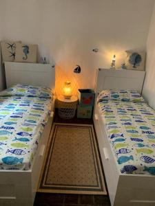 Duas camas sentadas uma ao lado da outra num quarto em Casa Gelsomino em Forte dei Marmi