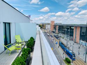 a balcony with chairs and a train on a city street at Mercure Krakow Stare Miasto in Krakow