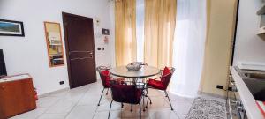 カンポフェリーチェ・ディ・ロッチェッラにあるL'angolo di Rosaのキッチン(テーブル、赤い椅子4脚付)