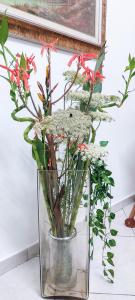 a glass vase with some flowers in it at L'angolo di Rosa in Campofelice di Roccella