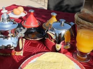 uma mesa com um prato de comida e algumas bebidas em Riad Pierres et Saveurs Soleil em Marrakech
