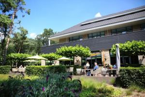 personnes assises à des tables devant un bâtiment dans l'établissement Van der Valk hotel Harderwijk, à Harderwijk