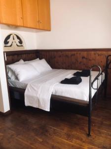 a bed with white sheets and a wooden headboard at Planitis Lighthouse View in Pánormos