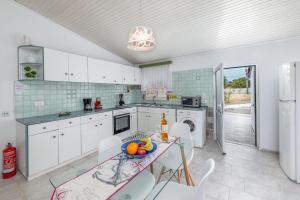 a kitchen with a table with a bowl of fruit on it at Beach House Cavo Kiotari in Gennadi