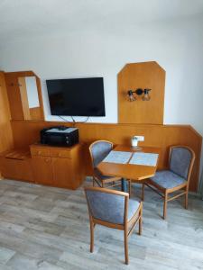 um quarto com uma mesa e cadeiras e uma televisão em Apartment Almberg em Mitterfirmiansreut