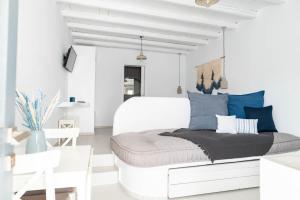 Dormitorio blanco con cama blanca y almohadas azules en Lemon tree lipsi, en Lipsi