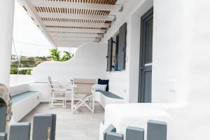 Cette chambre est dotée de murs blancs, d'une table et de chaises. dans l'établissement Lemon tree lipsi, à Lipsi