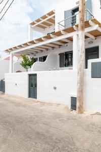 a white house with black windows and a pole at Lemon tree lipsi in Leipsoi
