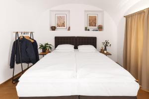 a bedroom with a large bed with white sheets at Hotel Baroko in Prague