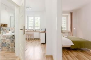 a white bedroom with a bed and a bathroom at Chill Apartments Praga Waszyngtona in Warsaw