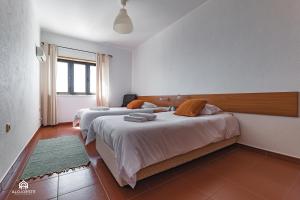 a bedroom with two beds and a window at Ondas do Pisão Apartment - 2 bedroom and Sea View in Santa Cruz