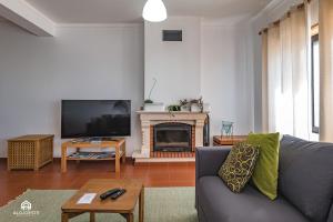 a living room with a couch and a fireplace at Ondas do Pisão Apartment - 2 bedroom and Sea View in Santa Cruz