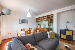 a living room with a couch and a dining room at Ondas do Pisão Apartment - 2 bedroom and Sea View in Santa Cruz