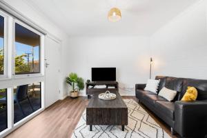 a living room with a couch and a table at Gateway Retreat near Flinders Uni & Hospital in Sturt