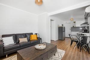 a living room with a couch and a table at Gateway Retreat near Flinders Uni & Hospital in Sturt