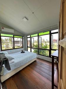 ein Schlafzimmer mit einem Bett in einem Zimmer mit Fenstern in der Unterkunft Sekepeng Penarek in Kampung Penarik