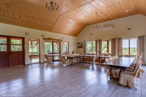 a large room with tables and chairs and windows at Mimoza Gospodarstwo Agroturystyczne in Bartoszyce