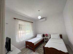 a room with two beds and a tv in it at Villa LIKAJ in Berat