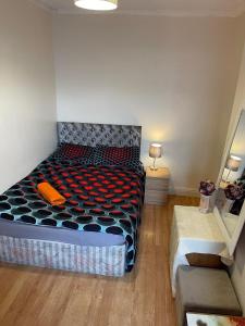 a bedroom with a bed with a black and orange comforter at Quite Broad rest 2 in Longford