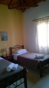 a bedroom with two beds and a window at Sipsas Villas in Koroni