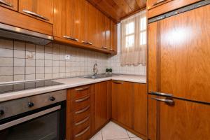a kitchen with wooden cabinets and a sink at Heaven's house in Kallirákhi