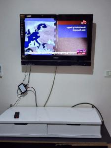 een televisie is bevestigd aan een muur met een controller bij شقه الهاني in Marsa Matruh