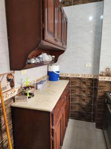 a kitchen with wooden cabinets and a counter top at شقه الهاني in Marsa Matruh
