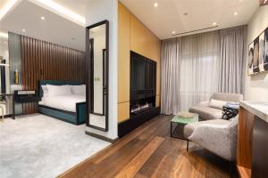 ein Schlafzimmer mit einem Bett, einer Couch und einem Spiegel in der Unterkunft Middle Eight - Covent Garden in London