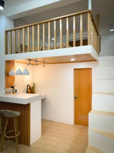 a loft kitchen with a staircase and a kitchen island at Ace Tiny Home in Alaminos - Home of the Hundred Islands in Alaminos
