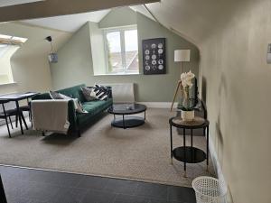 ein Wohnzimmer mit einer grünen Couch und einem Tisch in der Unterkunft Charming 1-Bed loft in Caerleon in Newport