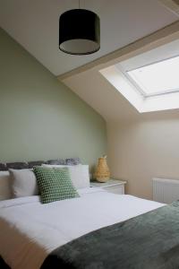 a bedroom with a large white bed with a skylight at Charming 1-Bed loft in Caerleon in Newport