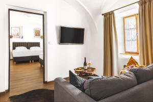 a living room with a couch and a tv on a wall at Hotel Baroko in Prague