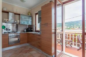 a kitchen with wooden cabinets and a balcony at Family Home - Garda 3 bedrooms apartment in Garda
