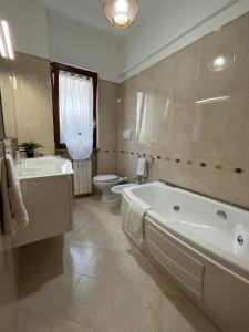 y baño con bañera, lavabo y aseo. en Clò House, en Fondi