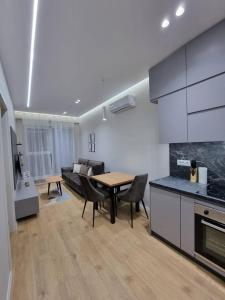 uma cozinha e sala de estar com uma mesa e um sofá em Anika Home Tirana 1 em Tirana