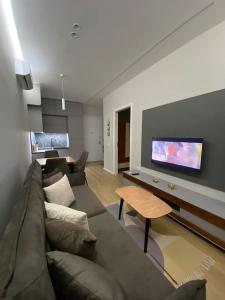- un salon avec un canapé et une télévision dans l'établissement Anika Home Tirana 1, à Tirana