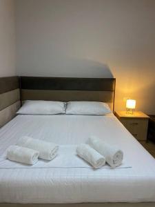 uma cama branca com duas almofadas em Anika Home Tirana 1 em Tirana