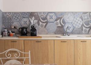 a kitchen with a counter with a tile wall at Camera Astrid in Casale Alxi