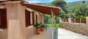 a house with a patio and a stone wall at VASIANA Country House in Razáta