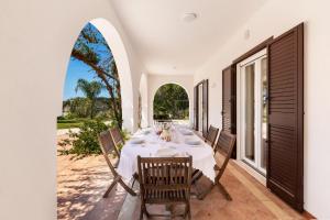 a dining table on the patio of a house at Villa Sunkiss by Perle di Puglia in Pulsano