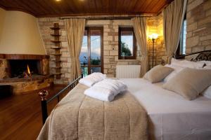 a bedroom with a large white bed with a fireplace at Nisista Lodge Mountain View in Rodavgi