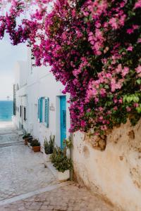 a street with pink flowers on a white building at Home Santa Clara in Albufeira