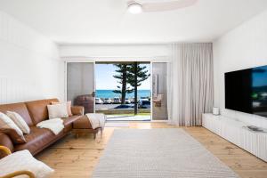 Henley Beach SouthにあるLuxury Beachfront Retreat on Henley Beach Esplanadeのソファとテレビのあるリビングルーム